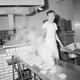 Steaming bagels are scooped out of the water in which they were boiled for two minutes and dumped onto a stainless steel drain board by Walter Scheuttig at the bagel bakery in Laurelton, Queens, New York City ,Nov. 15,1963. They will be transferred to cedar boards for baking. (AP Photo/Dan Grossi)